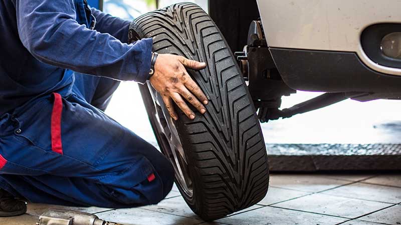 A car mechanic changes the tires of a vehicle